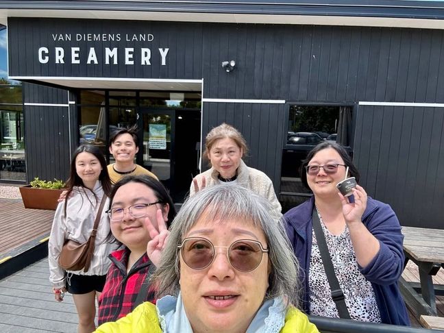 Happy family selfie in front of a store in Tasmania.