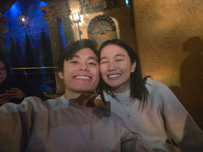 Toan and Wing smiling in Capitol Theatre. Dim lighting.