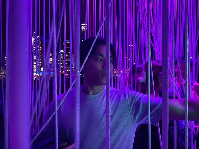 Photo of Toan touching strands of rope at VIVID Sydney